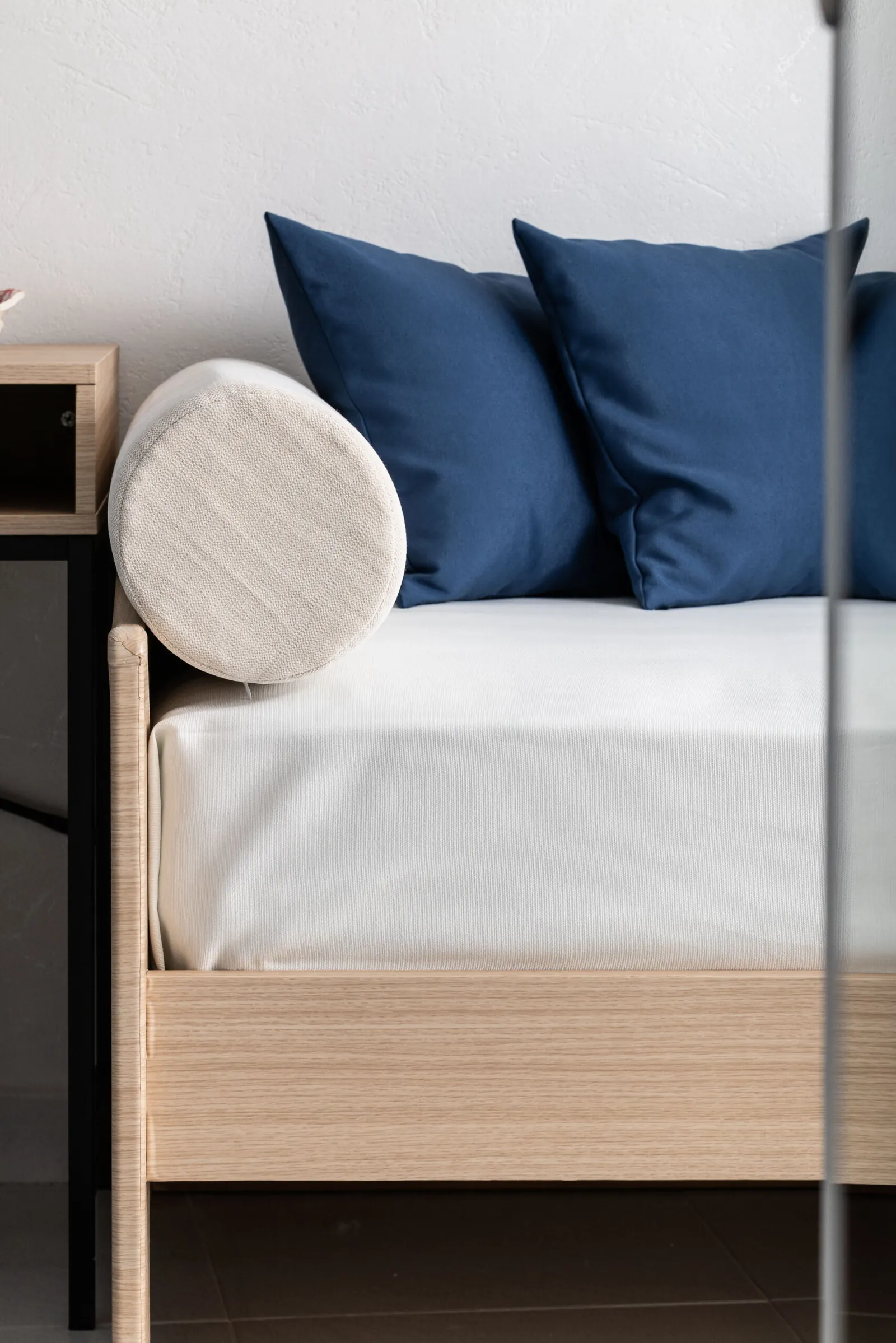 Divano letto con cuscini blu e cuscino a rullo