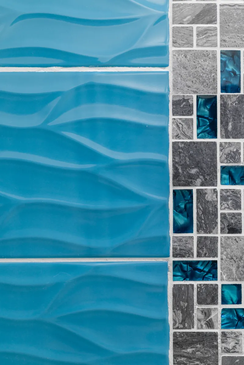 Piastrelle azzurre a onde e mosaico del bagno